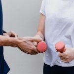 a man and a woman holding dumbs in their hands