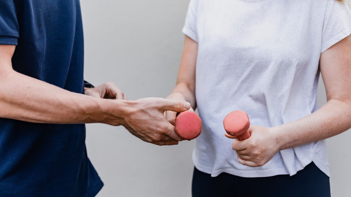 a man and a woman holding dumbs in their hands